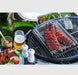 Grill tray with ribs on barbecue rack, served with beer, sauce, and salad outdoors