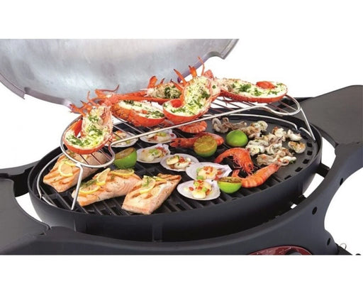 Seafood grilling on a barbecue rack with prawns, lobster, salmon, scallops, and lime halves
