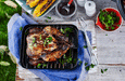 Grilled roast chicken on a rack pan, served with charred corn and fresh herbs outdoors